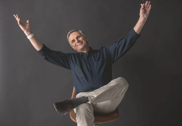 Viejo satisfecho gesticulando brazos — Foto de Stock