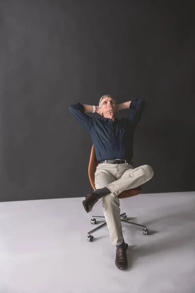 Zufriedener reifer Arbeitgeber, der sich auf seinem Sitz ausruht — Stockfoto