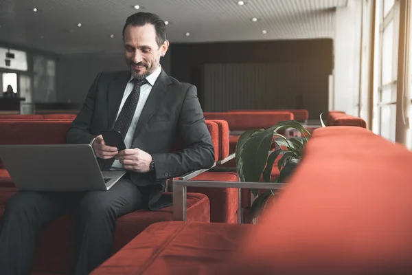 Cheerful gentleman using modern gadgets — Stock Photo, Image