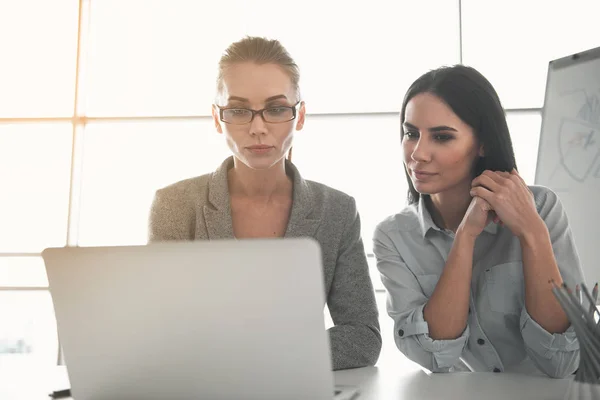 Businesswomen using gadget during teamwork