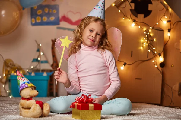 Joyful little girl in birthday cap