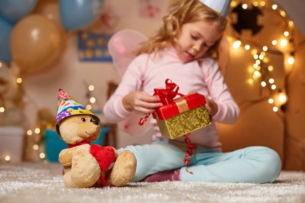 Interested little girl looking at gift — Stock Photo, Image