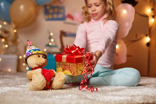 Alegre chica dando regalo a teddy — Foto de Stock