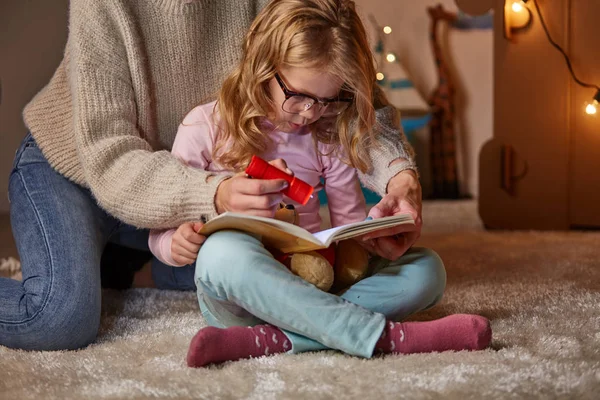 Mamá y su hija leyendo cuento de hadas en la habitación de los niños — Foto de Stock