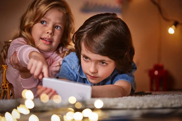 Amused children surfing internet with smartphone