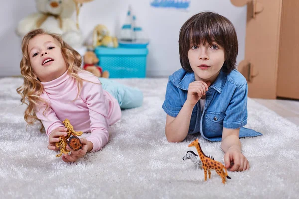 Niños sonrientes jugando en la habitación de los niños con juguetes — Foto de Stock