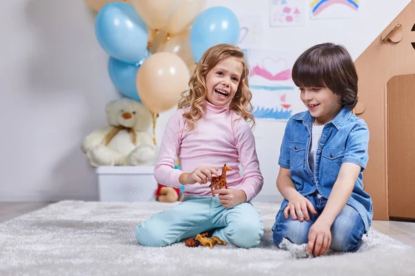 少年と少女が子供部屋で楽しく幸せな笑みを浮かべてください。 — ストック写真