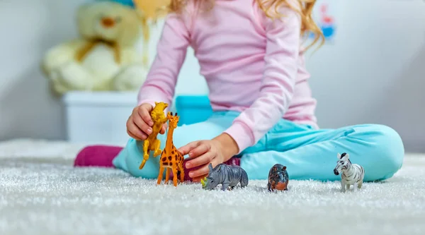 Niño jugando con juguetes en la alfombra en la sala de juegos — Foto de Stock