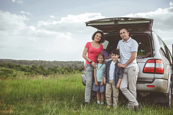 Vrolijke ouders en kinderen ontspannen op weide — Stockfoto