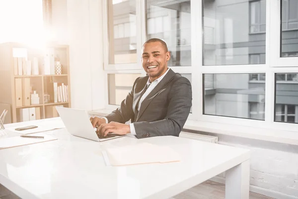 Blij dat Afrikaanse man werken bij kabinet en lachen — Stockfoto