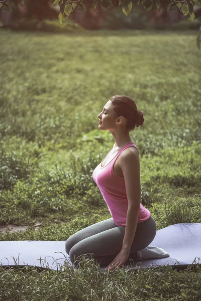 Мирная женщина практикует йогу на газоне — стоковое фото