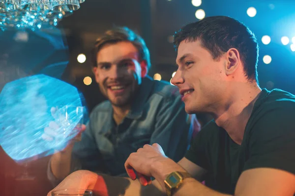 Des amis souriants parlent et boivent des cocktails — Photo