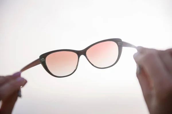 Леді проводить свої окуляри навпроти сонця — стокове фото