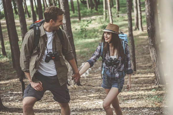 Petit ami optimiste et petite amie touristes marchent dans la pinède — Photo