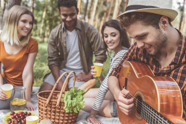 Blij metgezellen genieten van eten en muziek buitenshuis — Stockfoto