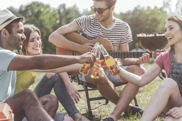 Śmiejąc się młodych ludzi do picia piwa na piknik — Zdjęcie stockowe