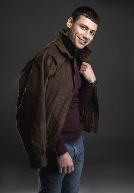 Neşeli adam rahat kıyafetler koyarak