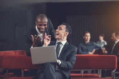 Laptop izlerken mutlu iş arkadaşları