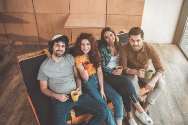 Neşeli öğrenciler lounge bölgedeki kanepede oturan