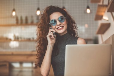 Neşeli kadın cep telefonu kafede söz