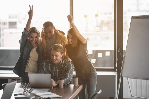 Equipe feliz olhando para a tela do computador — Fotografia de Stock