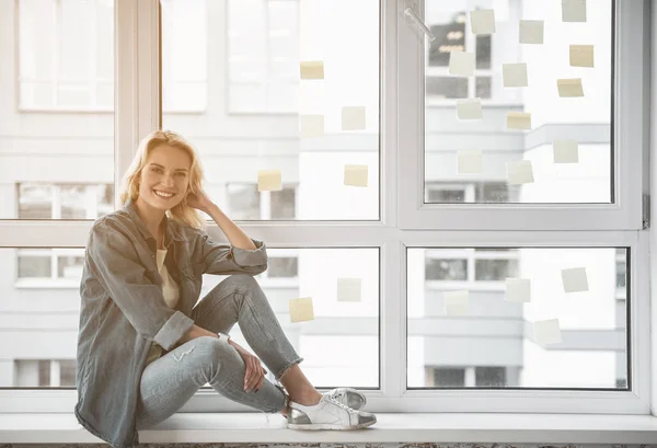 Usmívající se žena užívat odpočinku u okna — Stock fotografie