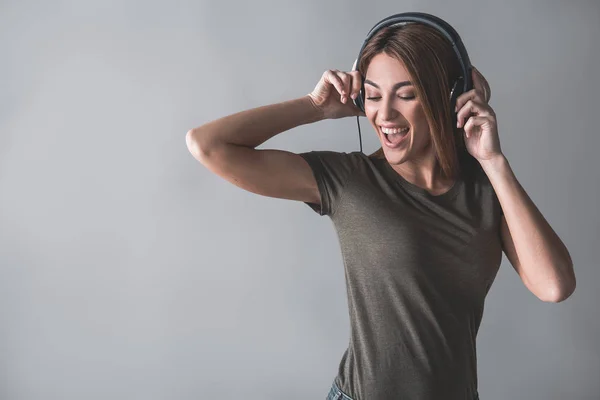 Muchacha encantada moviéndose bajo ritmo musical — Foto de Stock