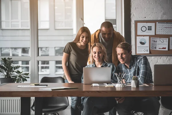 Gruppe von Mitarbeitern starrt freudig auf Laptop — Stockfoto