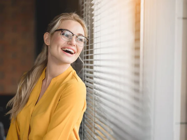 Mujer rubia relajada disfrutando de la vista desde la ventana —  Fotos de Stock