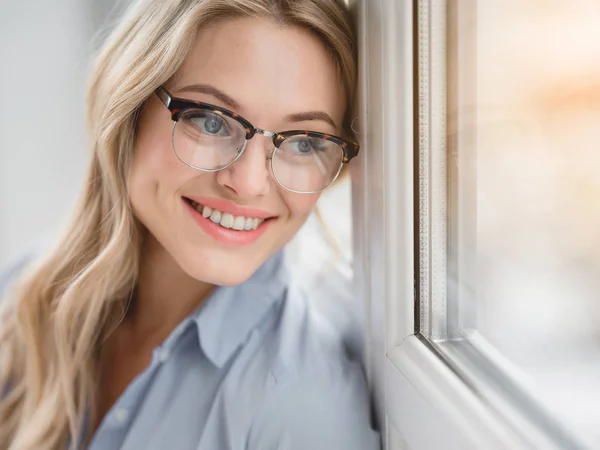 Jovem mulher alegre olhando sobre a janela — Fotografia de Stock