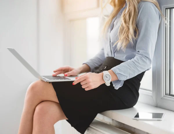 Businesswoman typing on notebook near window — Stock Photo, Image