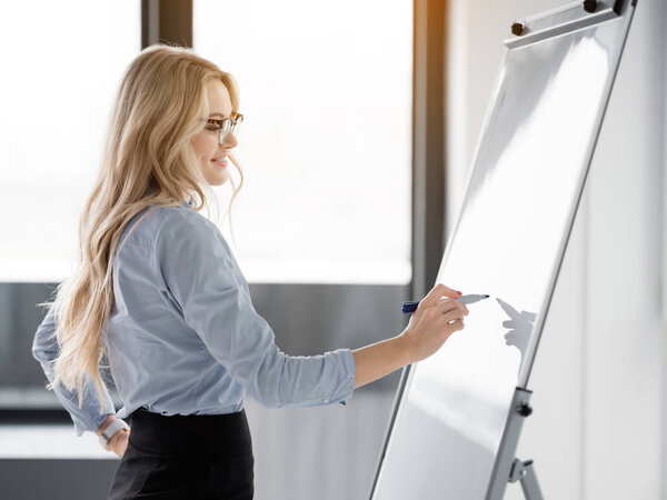 Smart blond lady noting her creative idea on board