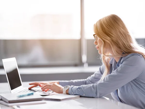 Ernstige zakenvrouw typen op laptop in kantoor — Stockfoto