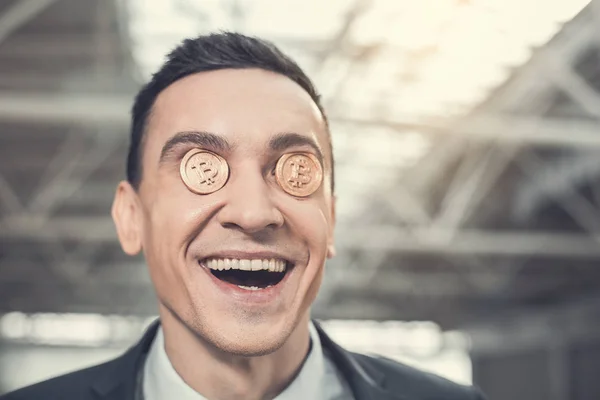 Tyytyväinen liikemies, jolla on kultainen raha kasvoilla — kuvapankkivalokuva