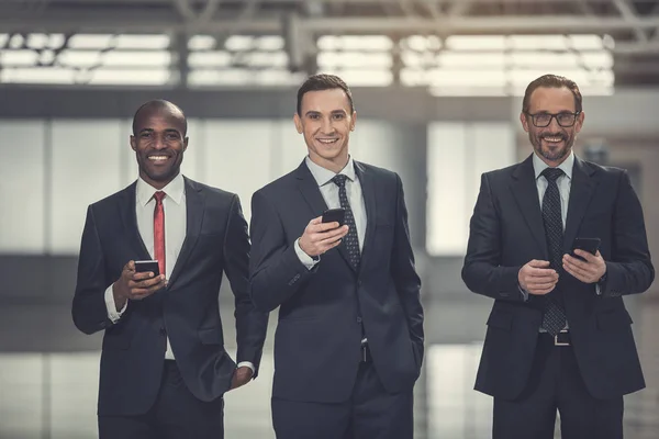 Empresários felizes trabalhando com telefones — Fotografia de Stock