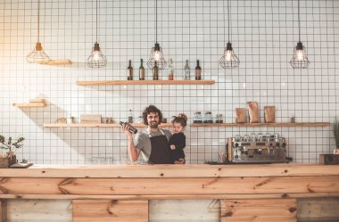 Neşeli adam küçük kızı kafeteryada çalışırken holding