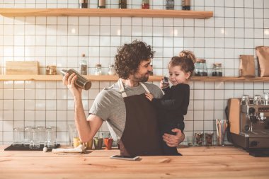 Küçük kızla kafede çalışması sırasında oynarken mutlu baba