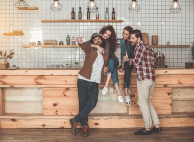 Neşeli genç erkek ve kadınların cep telefonundan fotoğraf çekmek