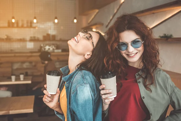 Alegre dos chicas disfrutando del café en la cafetería —  Fotos de Stock