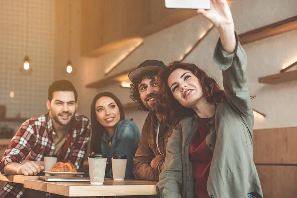 Sorglös studerande fotografera sig själva på telefonen i cafeterian — Stockfoto