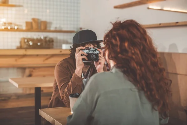 Glad ung man tar foto av kvinna inomhus — Stockfoto