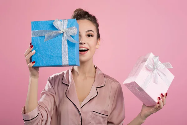 Оптимістична молода жінка покриває обличчя блакитного подарунка — стокове фото