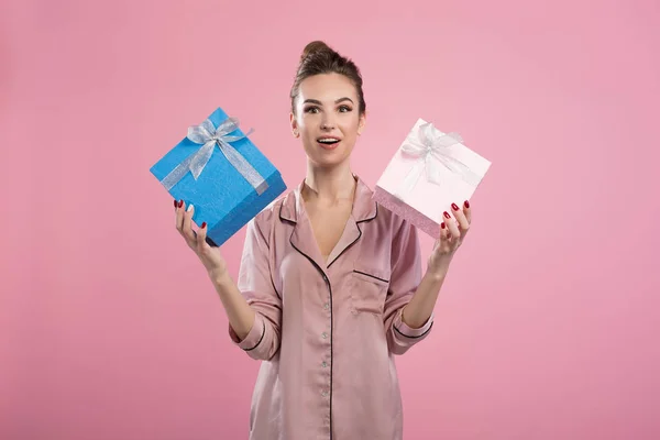 Здивована молода жінка тримає подарунки — стокове фото