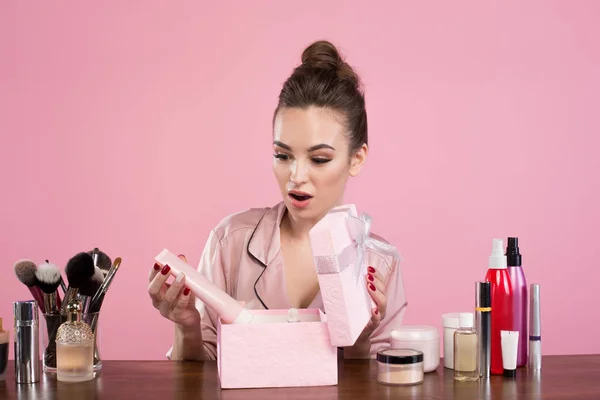 Young wondered woman is looking at her present — Stock Photo, Image