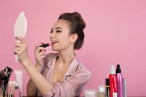 Cheerful girl is putting on makeup — Stock Photo, Image