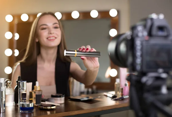 Positive young vlogger is showing new cosmetics product — Stock Photo, Image
