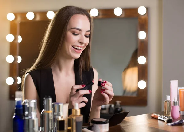 Optimistisch meisje houdt make-up product — Stockfoto