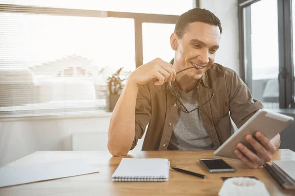 Uomo d'affari sorridente guardando tablet elettronico — Foto Stock