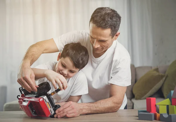 Amistosa familia reparación de coche de juguete en casa —  Fotos de Stock