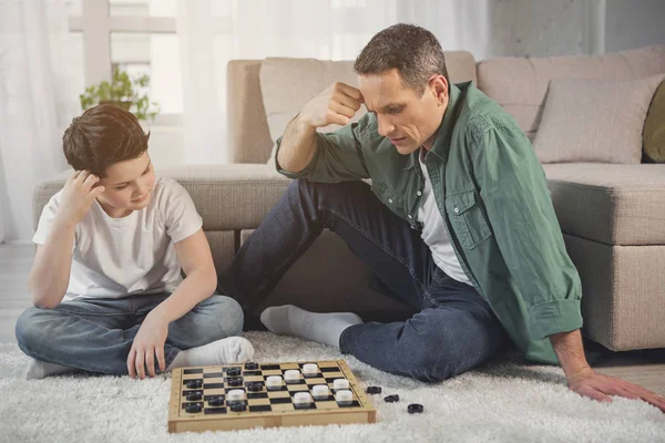 Man and boy entertaining with intellectual game at home